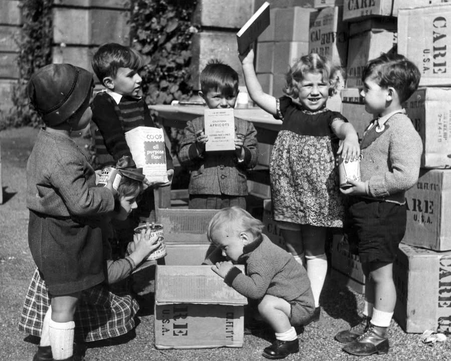 Staunende Kinder vor geöffnetem CARE-Paket. Foto: CARE Deutschland/Care.de