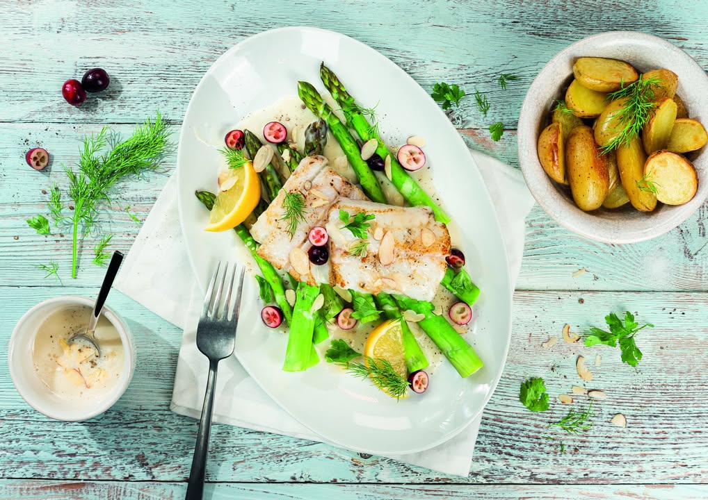 Das Heilbuttfilet wird mit grünem Spargel und Kartoffeln angerichtet – die Cranberries peppen das Gericht sowohl optisch als auch geschmacklich auf. Foto: Aquasale Meersalz